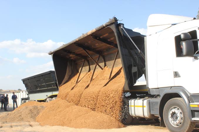 White tipper truck offloading sand at a depot